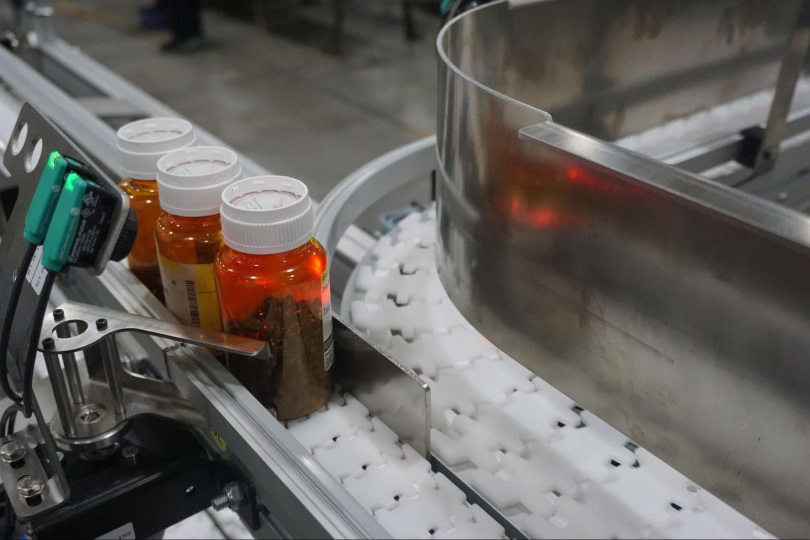 Conveyor carrying capped bottles along a production line